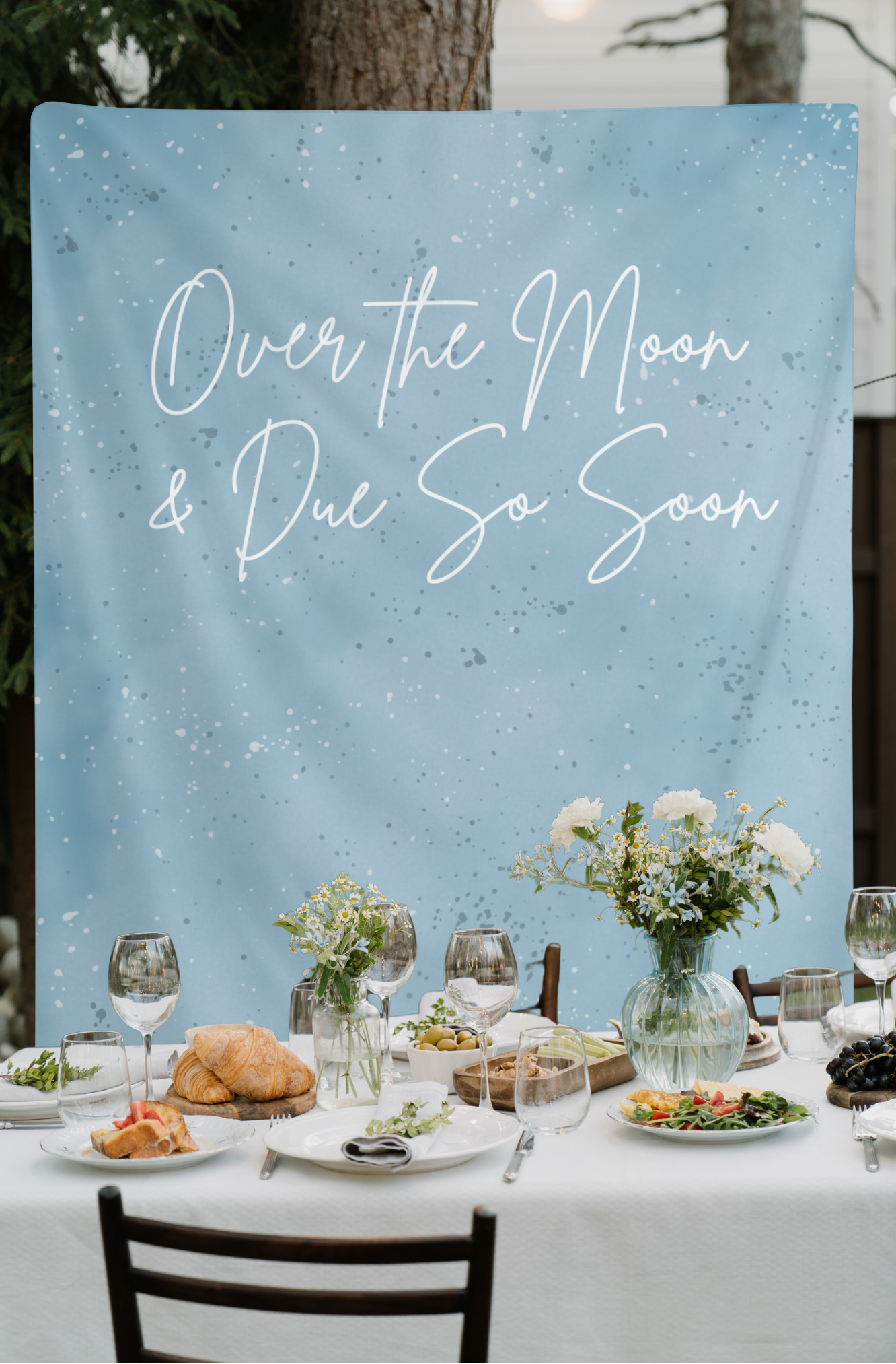 Table setting with 'Over the Moon & Due So Soon' backdrop
